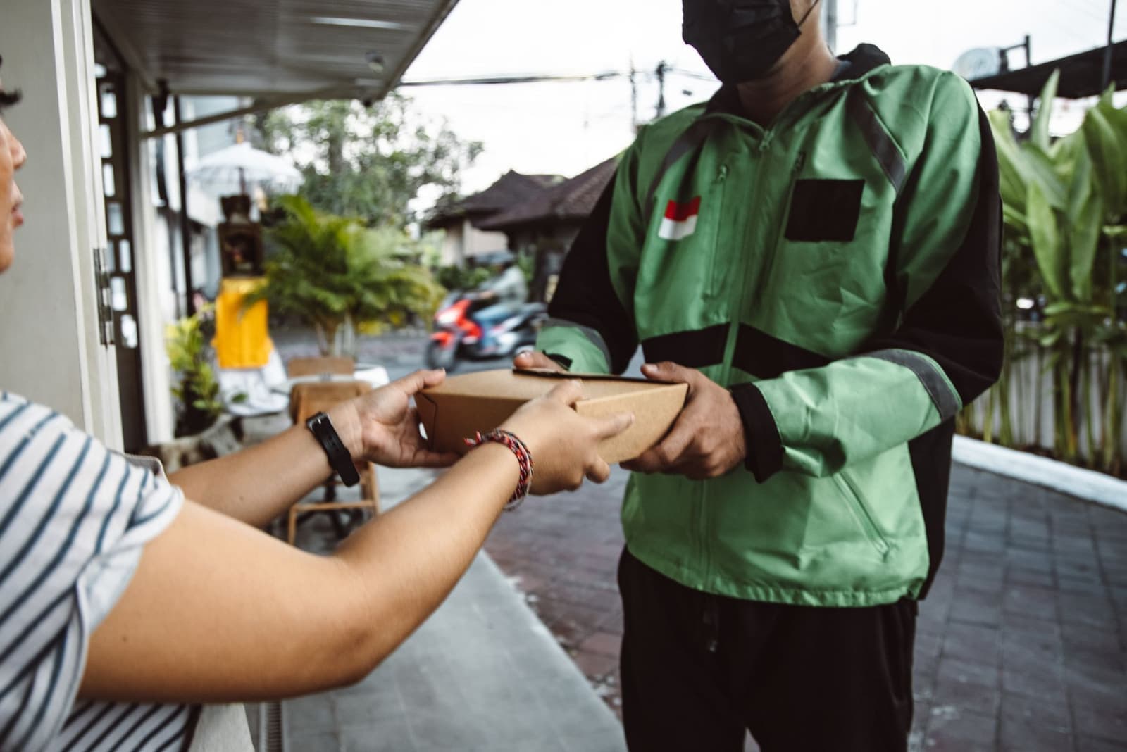 Courier handing a parcel to a customer